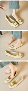 Detailaufnahme blassgelber Ballerinas mit goldener Vierkantschnalle und Webmuster