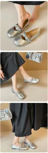 Detalle de bailarinas plateadas con cinta floral cruzada y bolso de mano a juego