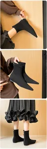 Detail of black pointed-toe sock boots with matte stretch fabric and silver back zipper
