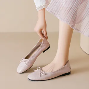 Ballerine rosa pallido con fiocco e trama intrecciata su sfondo minimalista