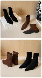 Detail view of black and brown suede ankle boots with back zipper and pointed toe