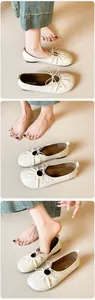 Close-up detail of soft off-white leather ballet flats with bow and ruched edges