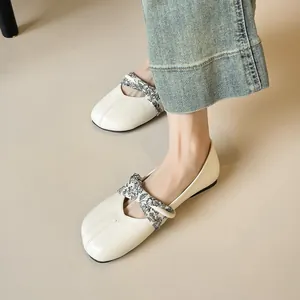 Bailarinas beige con correa estampada y punta redonda, combinadas con vaqueros