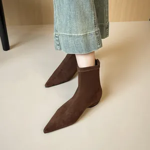 Deep brown pointed-toe matte suede sock boots with flat soles and minimalist design