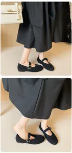 Detail of black suede Mary Jane flats with adjustable ankle strap and round toe design