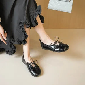 Classic black patent leather ballet flats with round toe and delicate bow detail