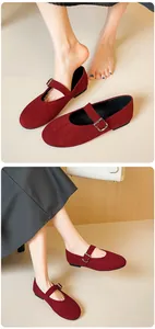 Detail of burgundy suede Mary Jane flat shoes with round toe and metal buckle strap