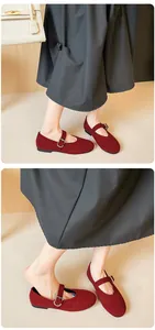 Detail view of burgundy suede Mary Jane flats with adjustable straps on a model