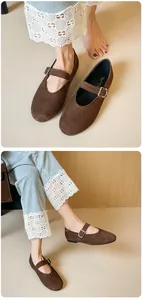Detail of dark brown suede Mary Jane flats featuring a round toe and silver buckle strap