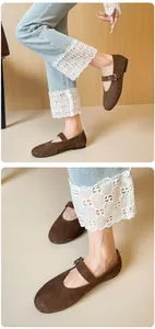 Close-up of brown suede Mary Jane flats with buckle strap and round toe detail
