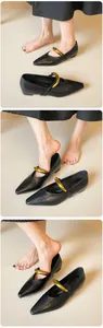 Detail von schwarzen spitzen Ballerinas mit goldener Schnalle und mattem Leder
