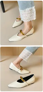 Nahaufnahme der cremefarbenen spitzen Mary Jane Ballerinas mit goldenem Metallriemen