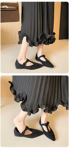 Détail de ballerines Mary Jane en daim noir mat avec bride en T sur un mannequin