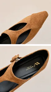 Détail de ballerines en daim marron à bout pointu avec logo de marque sur la semelle interne