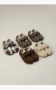Detailed view of fleece shoes in leopard print and grid patterns with buckle straps