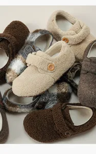 Detailed view of plush lamb wool slippers with velcro straps and wooden buttons