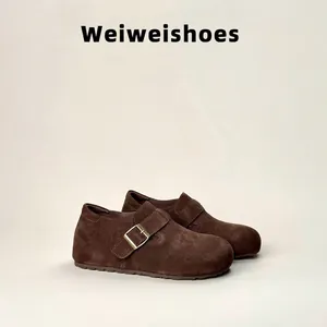 Deep brown suede platform slippers with adjustable metal buckles and round toe design