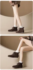 Lifestyle shot of dark brown suede lace-up boots showing styling and material details