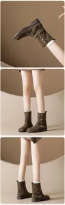 Detail view of brown suede mid-calf boots with buckle straps and rivet accents