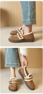 Detalle de mocasines con plataforma de pana marrón con pelo sintético blanco y hebilla