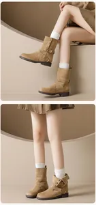 Detail of khaki suede mid-calf boots featuring double buckle straps and round toe design