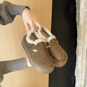 Brown platform Birkenstock-style clogs with warm white fleece lining and buckle detail