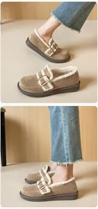 Detalle de mocasines con plataforma de ante caqui con forro de lana cálida y hebilla metálica