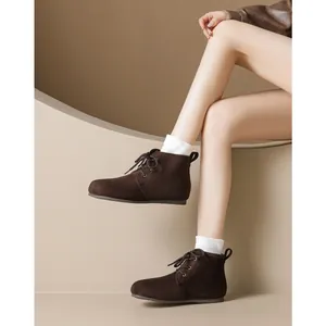 Deep brown suede lace-up boots with warm lining and flat soles on a model for winter
