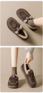 Détail d'un mocassin en daim marron avec doublure polaire et coutures décoratives blanches