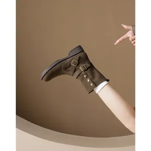 Brown suede ankle boots with vintage metal buckles and studs in a side-view studio shot