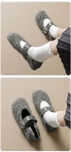 Dettaglio di ballerine Mary Jane in lana grigia con cinturino in pelle e fibbia in metallo