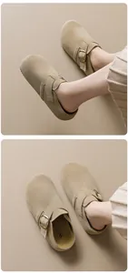 Détail de sabots en daim kaki avec boucle en bronze réglable et semelle à plateforme