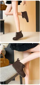 Bottines à lacets en daim marron foncé portées dans un intérieur moderne chic