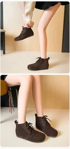 Détail de bottines à lacets en daim marron foncé avec bout rond et semelle plate