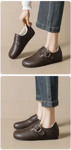 Gros plan de sabots Birkenstock marron foncé avec doublure en peluche et boucle métal
