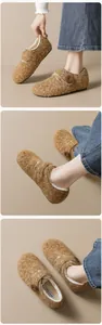 Detail von braunen Fleece-Clogs mit warmem Plüschfutter und dekorativem Holzknopf