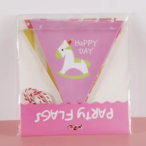 Detail of paper party flags with carousel horse print and Happy Day text in packaging