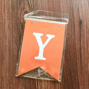 Detail of an orange swallowtail banner with a white letter Y in transparent packaging