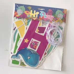 Detail of shark-themed happy birthday banner with whale cards and white ribbon