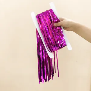 Close-up of metallic rose purple tinsel fringe curtain wrapped on white cardboard card