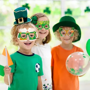 Kinder mit St. Patrick's Day Party-Requisiten wie Glücksbrillen und grünen Hüten
