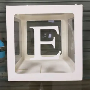 Détail d'une boîte à ballons blanche avec fenêtre transparente et lettre E décorative