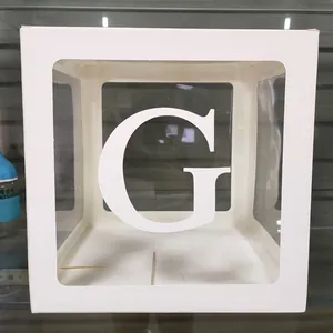 Détail d'une boîte de décoration de fête blanche avec fenêtre transparente et lettre G