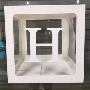 Détail de la boîte à ballons transparente avec lettre H 3D pour décor de fête