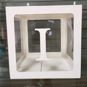 Gros plan d'une boîte à ballons blanche avec fenêtre transparente et lettre I décorative