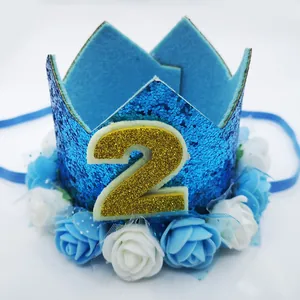 Macro view of blue glitter 2nd birthday party crown with fabric roses and elastic strap