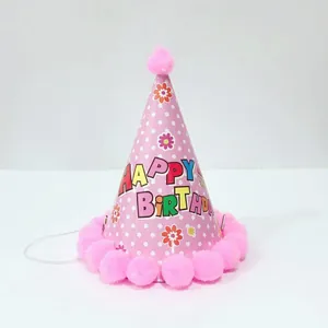 Detail van roze verjaardagsmuts met stippen, pompons en Happy Birthday tekstprint
