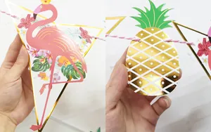 Dettaglio di ghirlanda tropicale con ananas in lamina d'oro e fenicotteri rosa