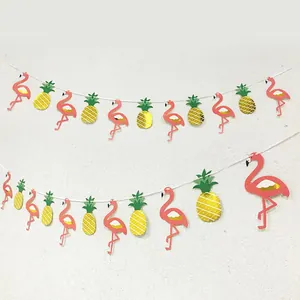 Dettaglio di striscione con fenicotteri e ananas con glitter oro per feste tropicali