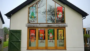 Close-up of six festive Christmas vertical banners hanging on a white house window